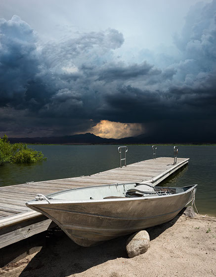 Color photograph of a boat and storm in Lake Henshaw, San Diego